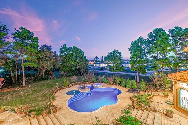 pool at dusk featuring a patio and a hot tub