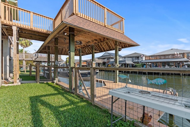 view of dock with a deck with water view and a yard