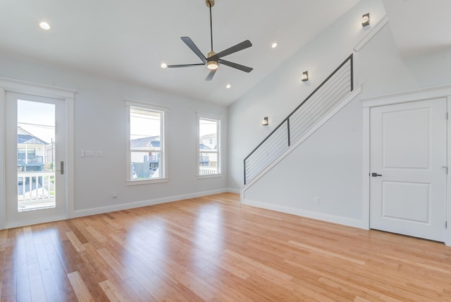 unfurnished living room featuring ceiling fan, light wood-type flooring, and lofted ceiling