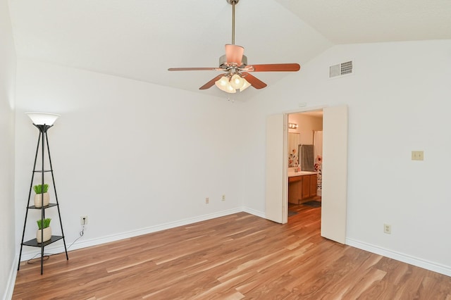 spare room with lofted ceiling, ceiling fan, and light wood-type flooring