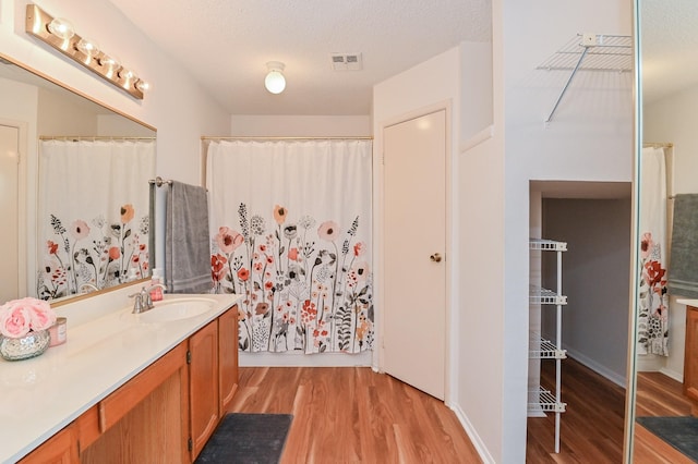 bathroom with a shower with shower curtain, a textured ceiling, vanity, and hardwood / wood-style flooring