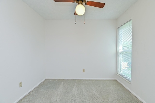 carpeted spare room with ceiling fan