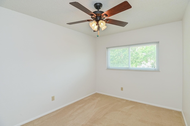 empty room featuring ceiling fan and light colored carpet