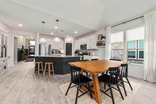 dining room featuring light hardwood / wood-style floors and vaulted ceiling