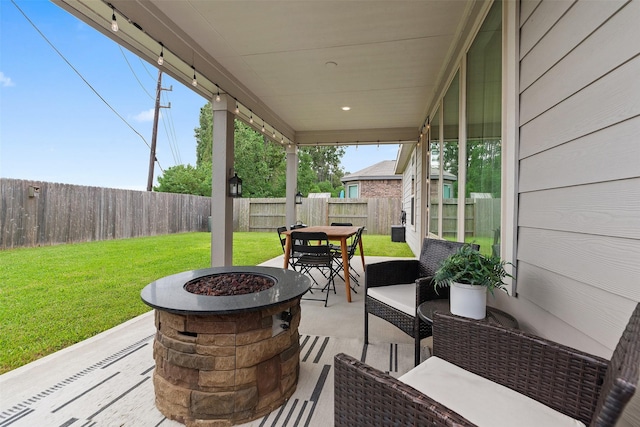 view of patio with an outdoor living space with a fire pit