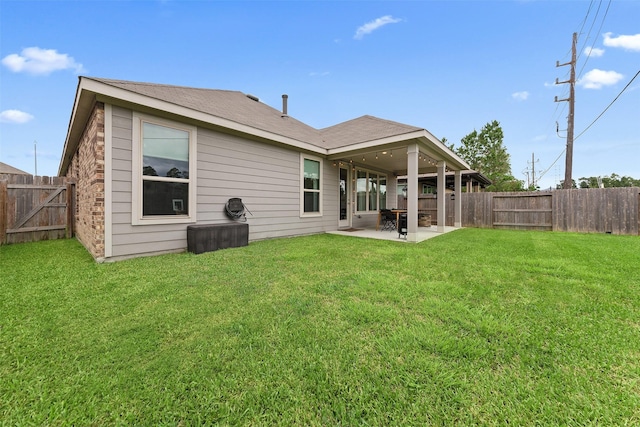 back of property with a patio area and a lawn