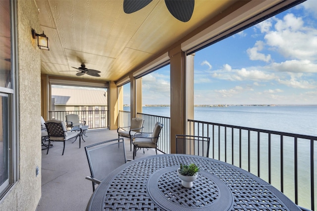 exterior space featuring ceiling fan and a water view