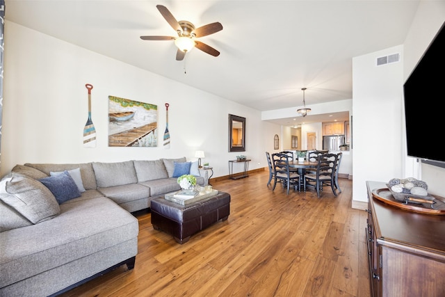 living room with ceiling fan and hardwood / wood-style flooring