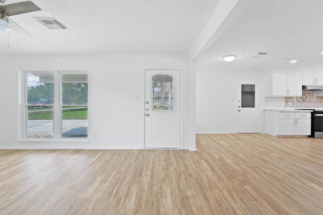 unfurnished living room featuring crown molding and light hardwood / wood-style floors