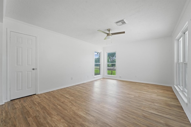 empty room with ceiling fan, crown molding, and hardwood / wood-style flooring