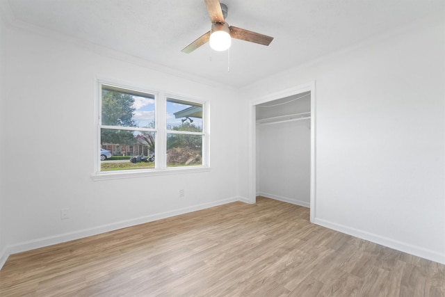 unfurnished bedroom with light wood-type flooring, a closet, ceiling fan, and crown molding