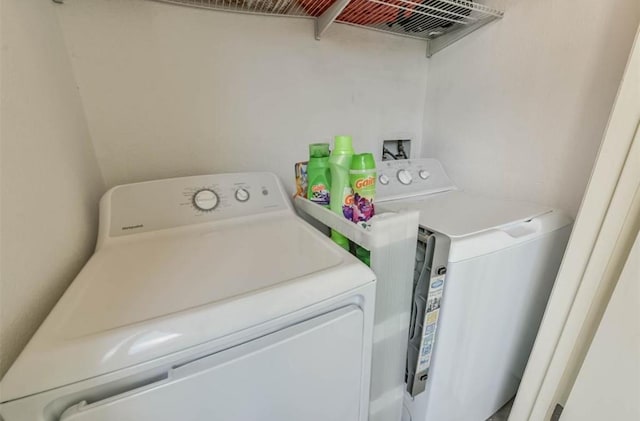 clothes washing area featuring separate washer and dryer