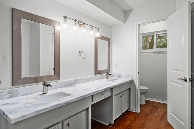 bathroom featuring wood-type flooring, vanity, and toilet