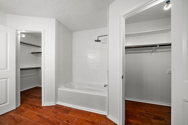 bathroom with a textured ceiling and shower / bath combination