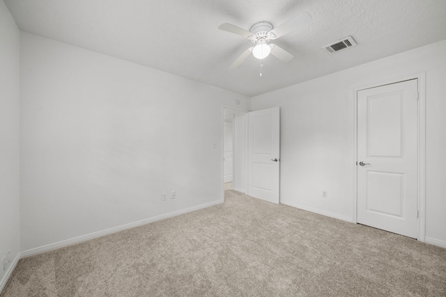 spare room featuring ceiling fan, carpet floors, and a textured ceiling