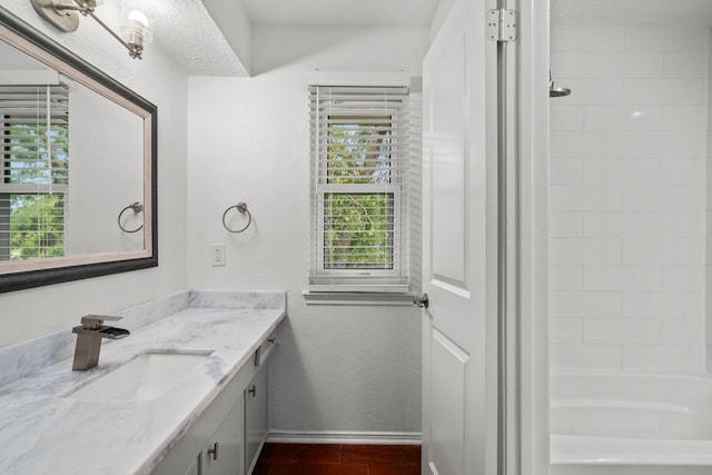 bathroom featuring hardwood / wood-style floors, vanity, and tiled shower / bath