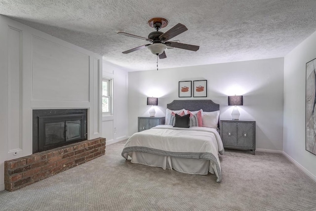 carpeted bedroom featuring ceiling fan, a textured ceiling, and a brick fireplace