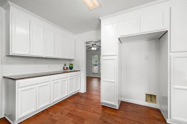 kitchen with dark hardwood / wood-style floors, dark stone countertops, and white cabinetry