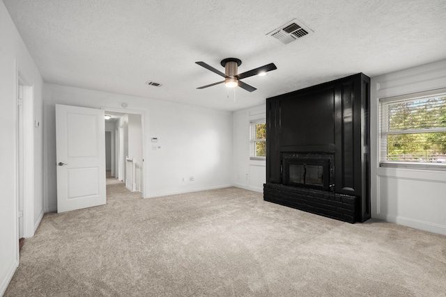 unfurnished bedroom featuring multiple windows, light colored carpet, and ceiling fan