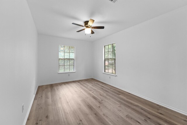 unfurnished room featuring light wood-type flooring, ceiling fan, and a healthy amount of sunlight