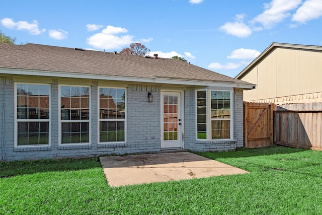 back of property with a yard and a patio