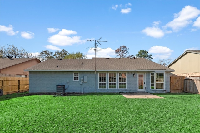 back of house featuring a yard, central AC, and a patio area