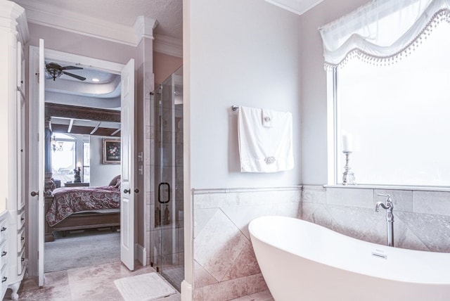 bathroom featuring ornamental molding, separate shower and tub, ceiling fan, and tile walls