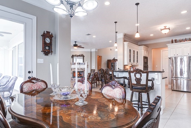 tiled dining space with plenty of natural light, ceiling fan with notable chandelier, and ornamental molding