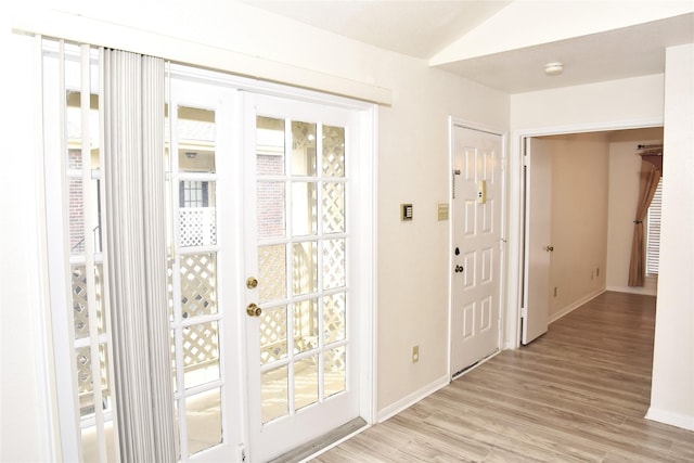 entryway featuring lofted ceiling and light hardwood / wood-style flooring