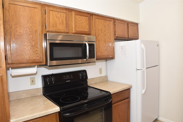 kitchen featuring black electric range and white refrigerator