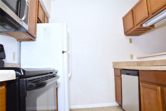 kitchen with stainless steel appliances and light tile patterned flooring