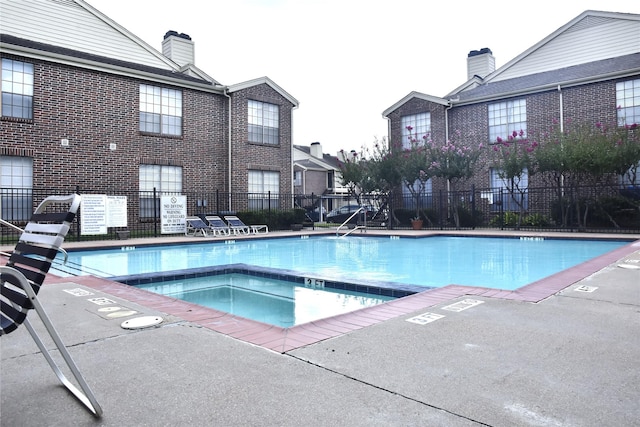 view of swimming pool featuring a community hot tub