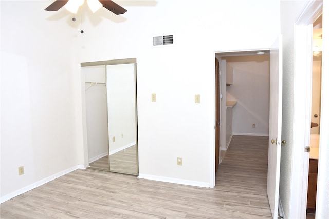 unfurnished bedroom featuring a closet, light hardwood / wood-style floors, and ceiling fan