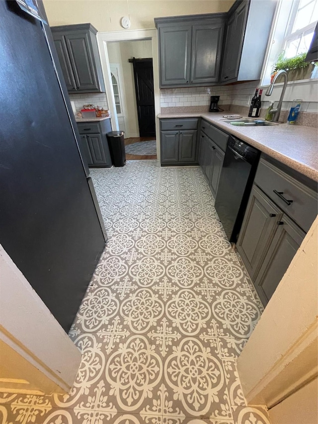 kitchen featuring decorative backsplash, black dishwasher, gray cabinets, and sink