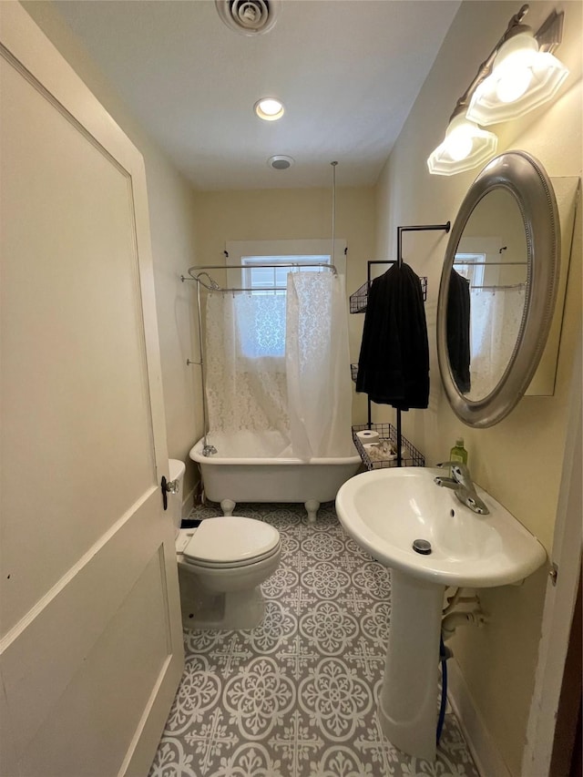 full bathroom featuring tile patterned flooring, toilet, shower / bathtub combination with curtain, and sink