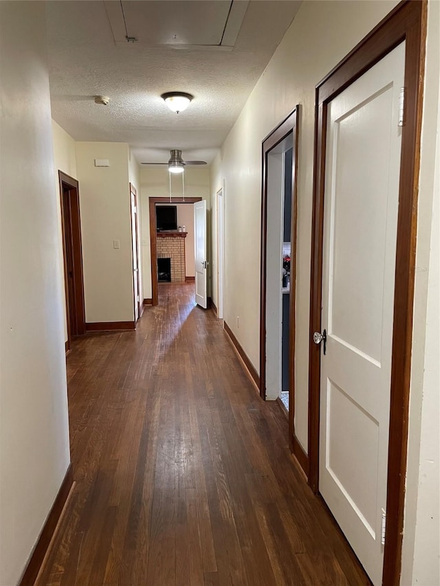 corridor featuring a textured ceiling and dark wood-type flooring