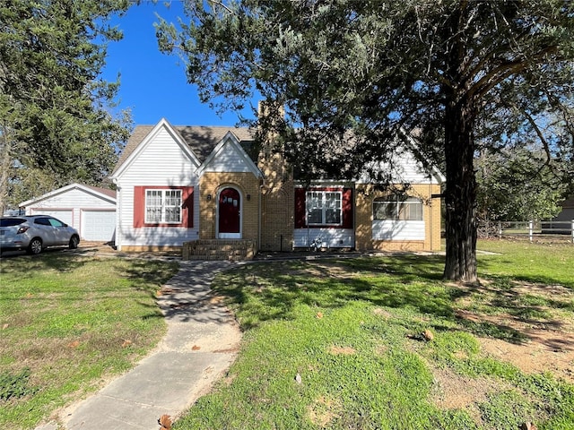 view of front of house featuring an outbuilding, a garage, and a front lawn