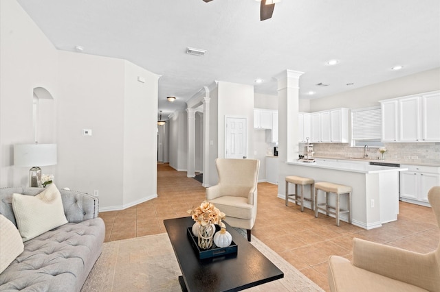 tiled living room featuring ceiling fan and sink