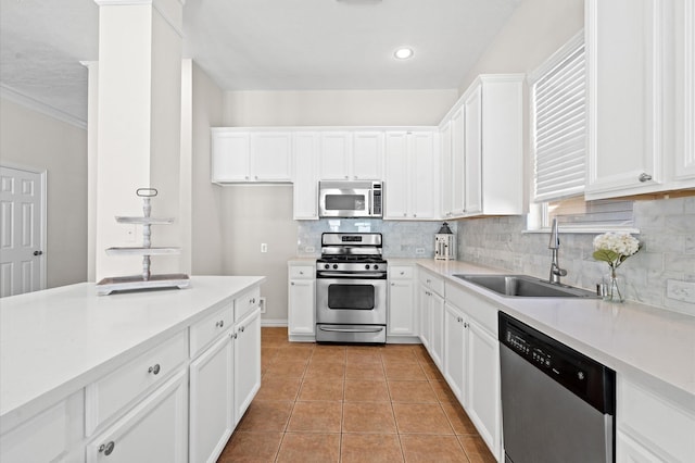 kitchen with sink, tasteful backsplash, light tile patterned flooring, white cabinetry, and stainless steel appliances