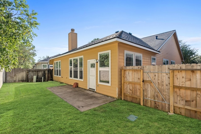 back of house with a lawn and a patio area