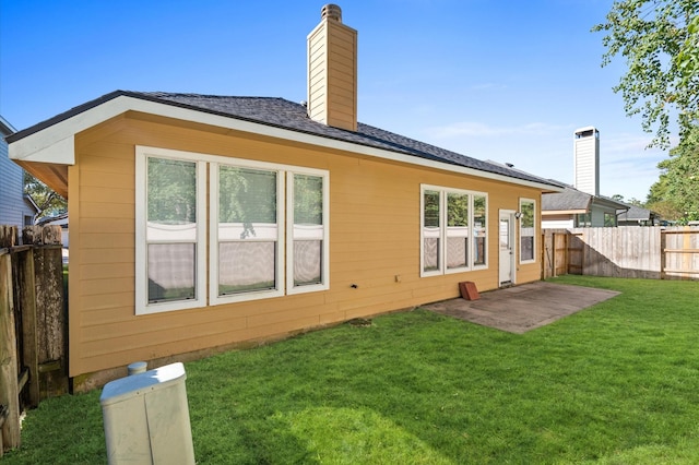 back of property featuring a yard and a patio