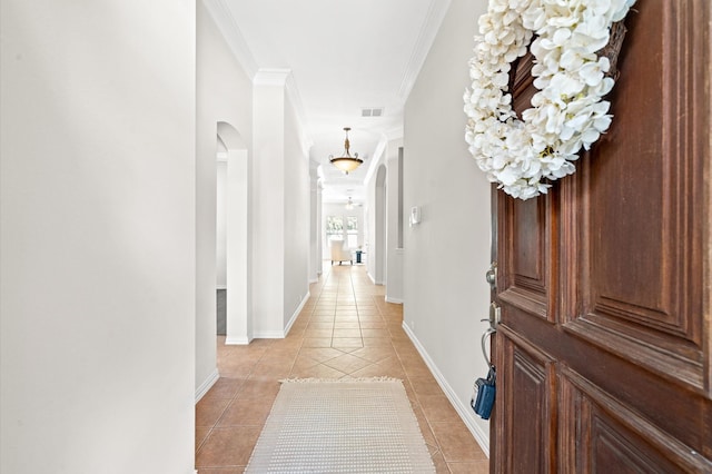 corridor featuring light tile patterned floors and ornamental molding