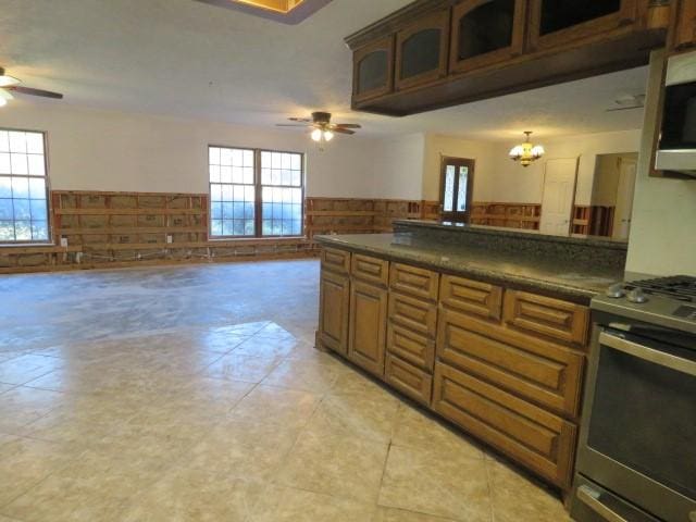 kitchen featuring ceiling fan with notable chandelier and stainless steel range oven