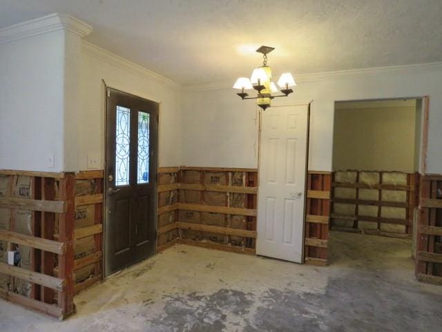 foyer entrance with a chandelier, french doors, and crown molding