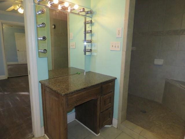 bathroom featuring vanity, tile patterned flooring, ceiling fan, ornamental molding, and tiled shower