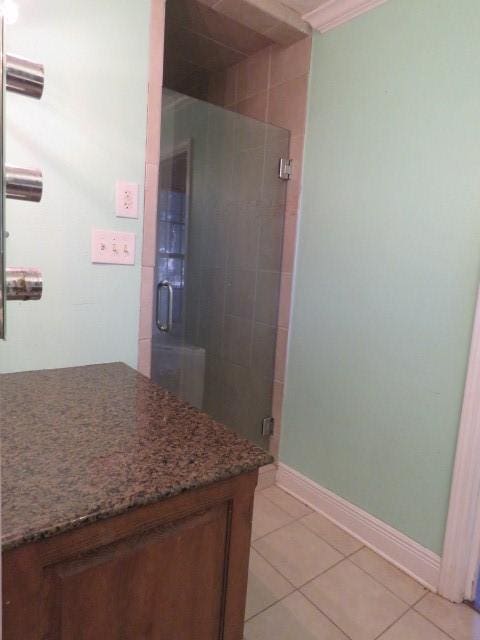 bathroom with tile patterned floors, walk in shower, and crown molding