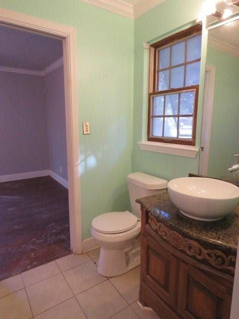 bathroom with tile patterned flooring, vanity, toilet, and crown molding