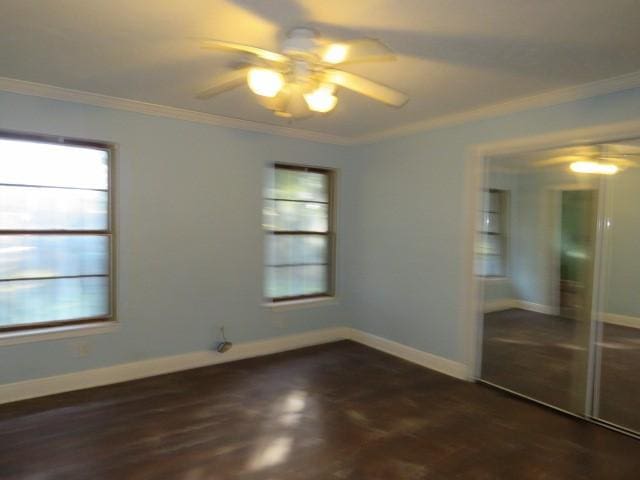 unfurnished bedroom featuring a closet, ceiling fan, crown molding, and dark parquet floors