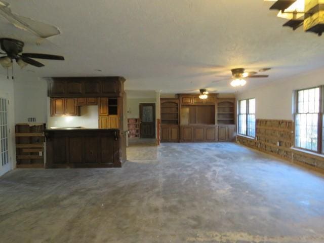 unfurnished living room featuring ceiling fan