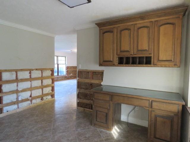 unfurnished office with dark tile patterned flooring and crown molding